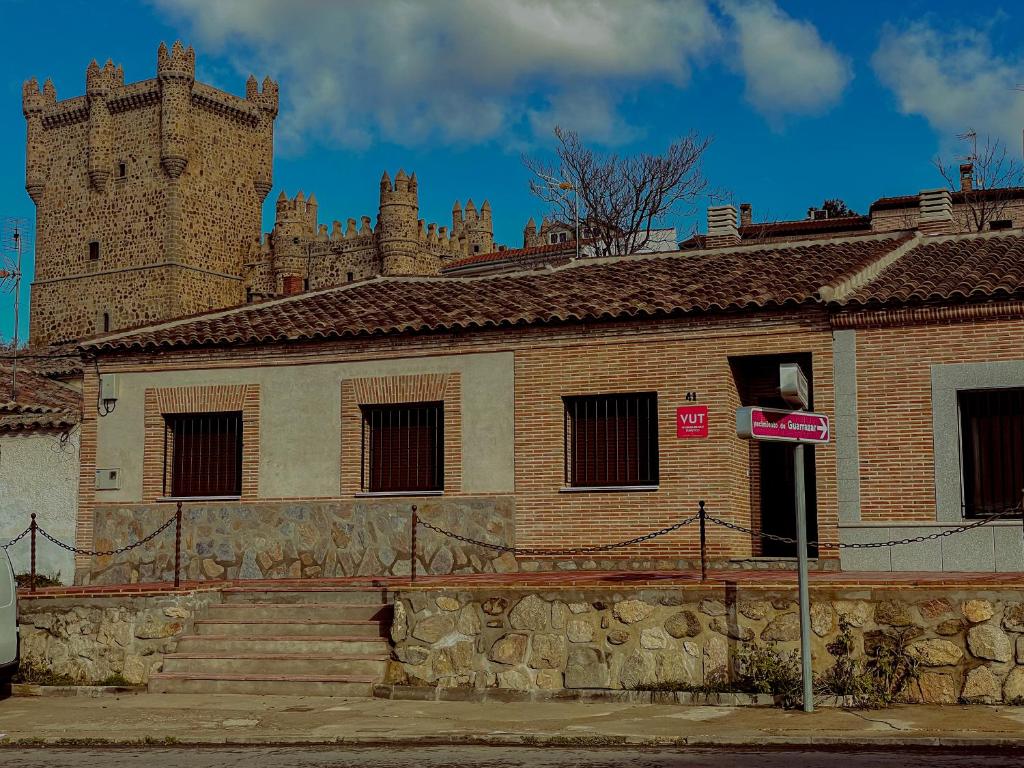 a brick building with a castle in the background at Casa Sol del Prado, Cerca De Puy Du Fou in Guadamur