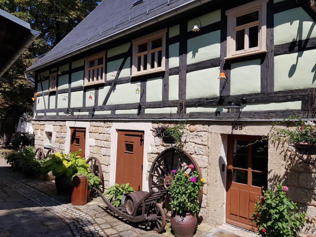 an old building with a wheel in front of it at Gohrischer Hof Anno 1798 in Kurort Gohrisch