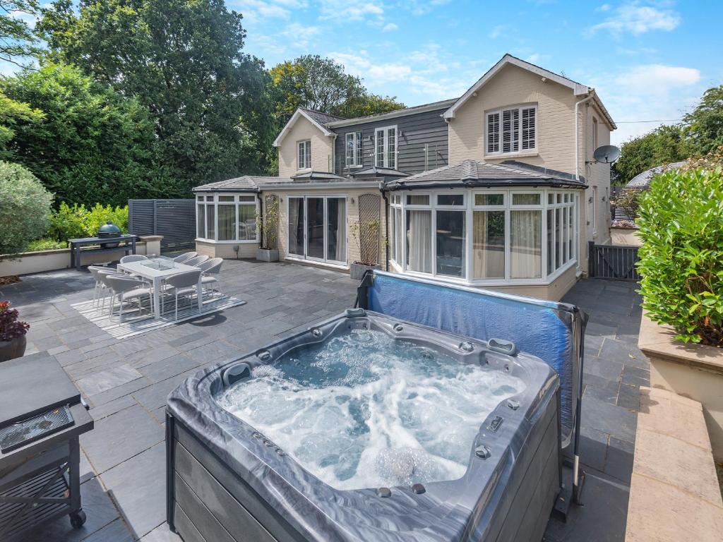 a hot tub on a patio in front of a house at Woodlea Farm in Four Marks