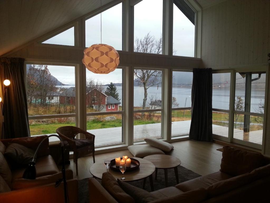 a living room with a large group of windows at Moderne feriehus in Laupstad