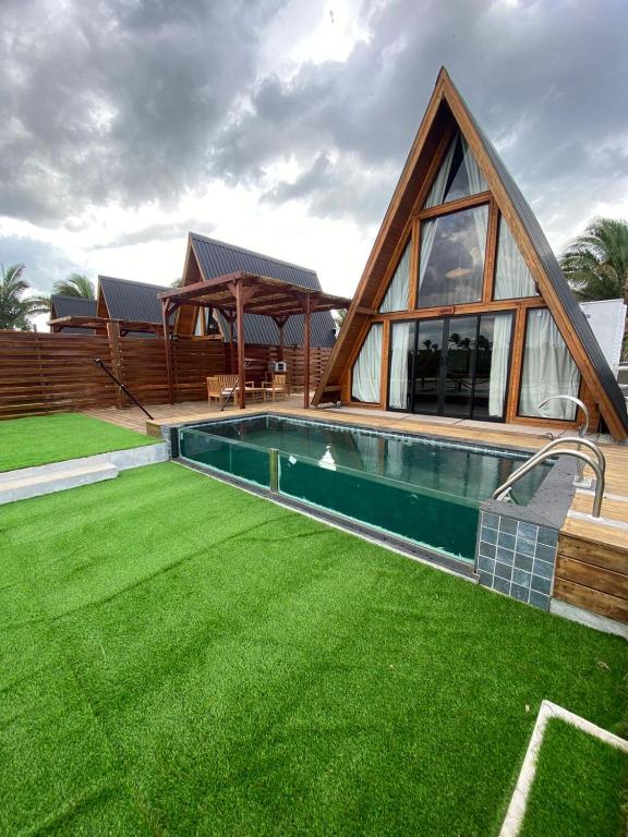 a house with a pool and a grass yard at LIMMAT Chalés- Presidente Juscelino, MA in Morros