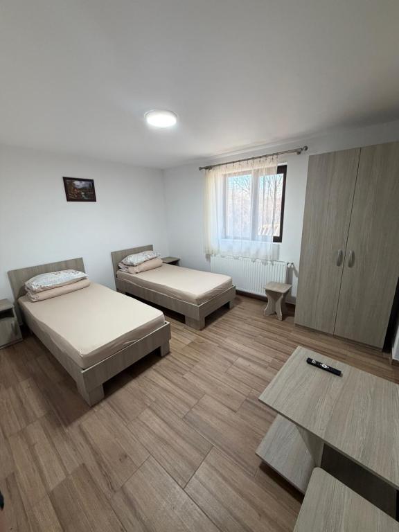 a room with two beds and a table at Casa Drăghici in Nucet