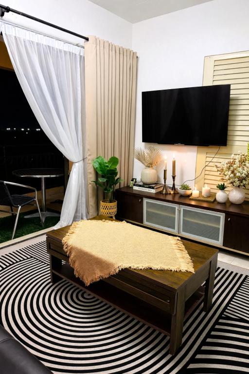 a living room with a flat screen tv and a coffee table at Homestay Tysha in Kampong Pulau Sebang