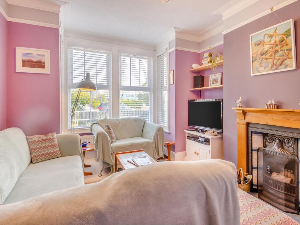 a living room with purple walls and a fireplace at Beachcombers Retreat in Felixstowe