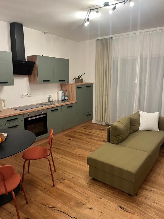a living room with a couch and a kitchen at Moderne Apartments in Wicker in Flörsheim am Main