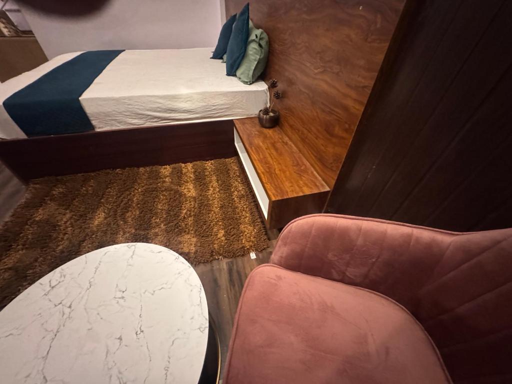 a small room with a bed and a chair at hotel Atithii in Rīngas