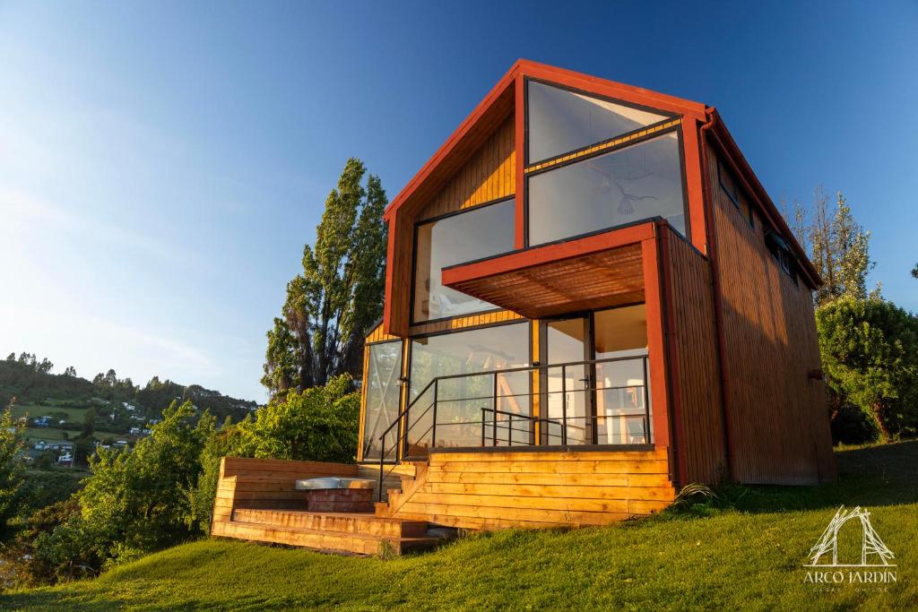 a house on top of a grassy hill at Casas Arco Jardin in Castro