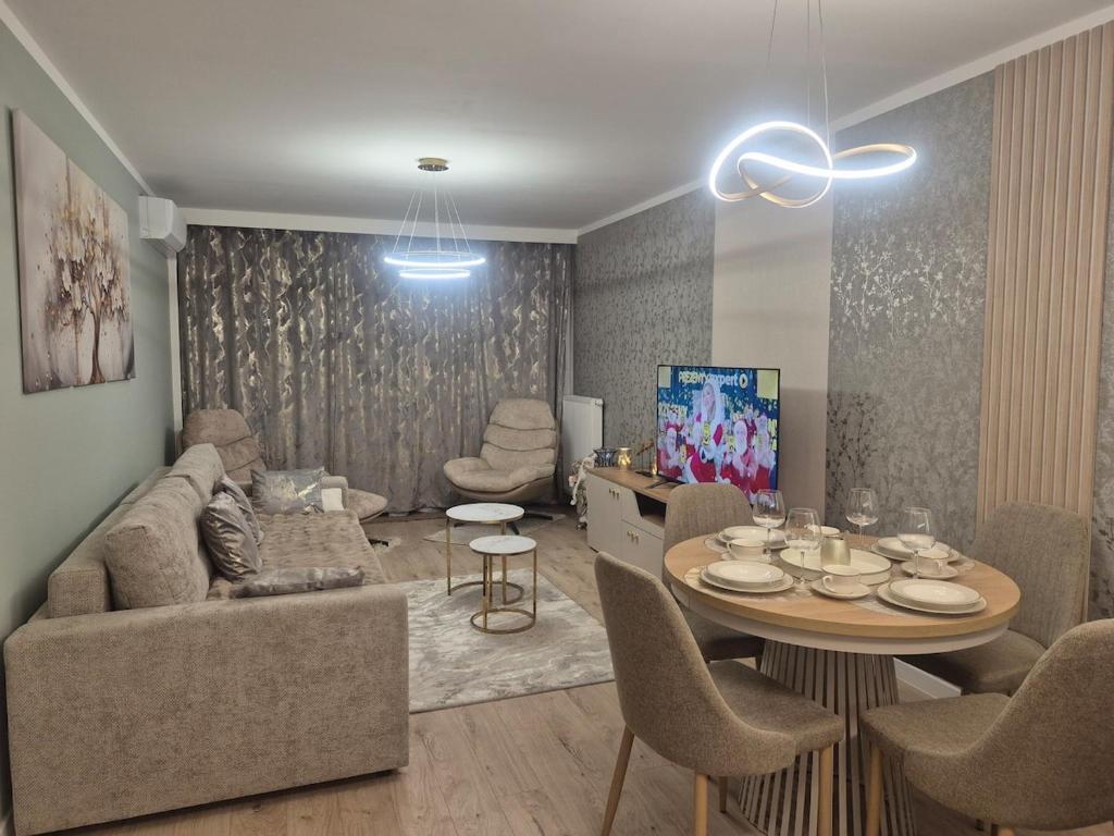 a living room with a couch and a table with chairs at Major Apartment in Dziwnów