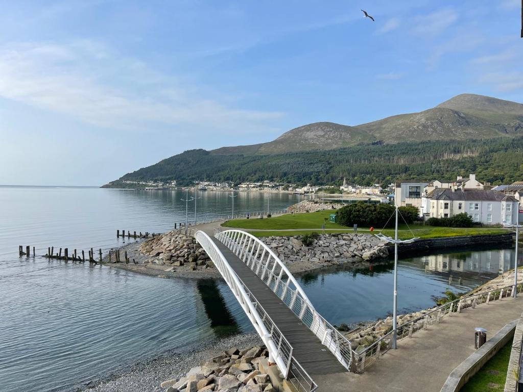 a bridge over a body of water with mountains in the background at John's Luxury Seafront Apartment in Newcastle