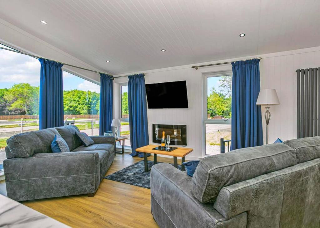 a living room with two couches and a tv at Finest Retreats - Silverwood Junior Chalet in Errol