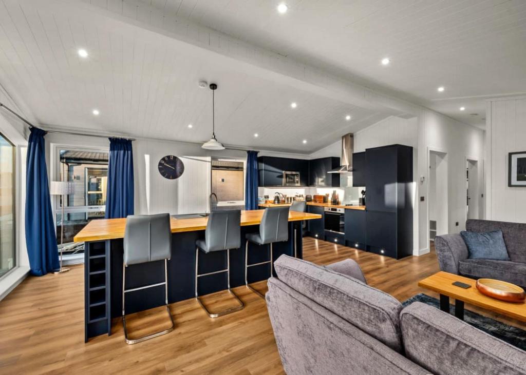 a kitchen and living room with a couch and a table at Finest Retreats - Silverwood Premium Chalet in Errol