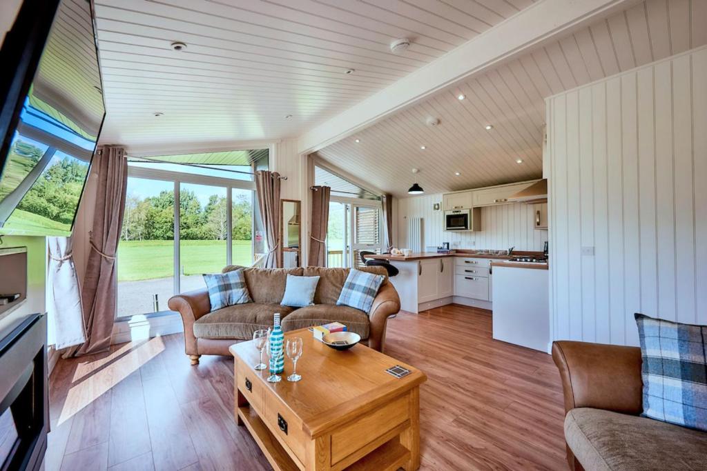 a living room with a couch and a table at Finest Retreats - Silverwood Spa Lodge in Errol