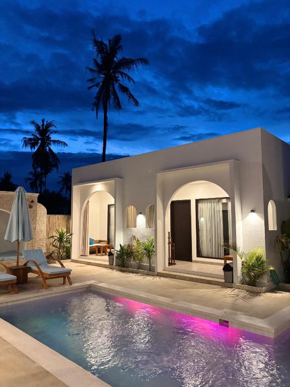 a villa with a swimming pool at night at White Seeds Boutique Villas in Gili Trawangan