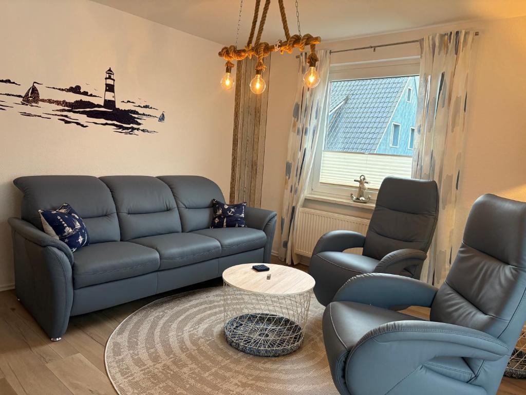 a living room with a couch and two chairs and a table at Ferienhaus Edda in Timmendorfer Strand