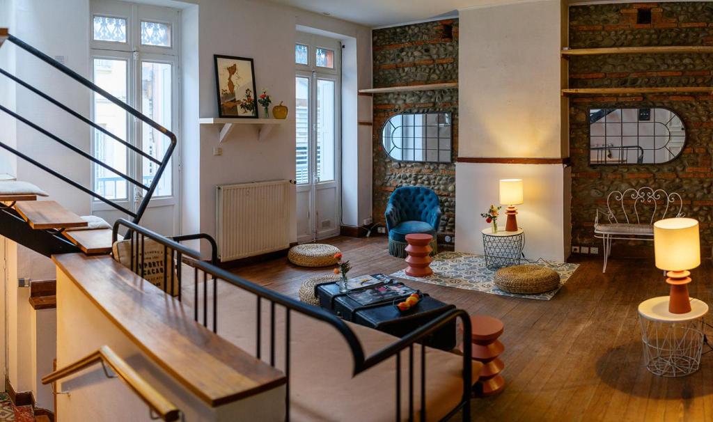 a living room with a staircase and a room with a table at Maison Bonnefoy Toulouse in Toulouse