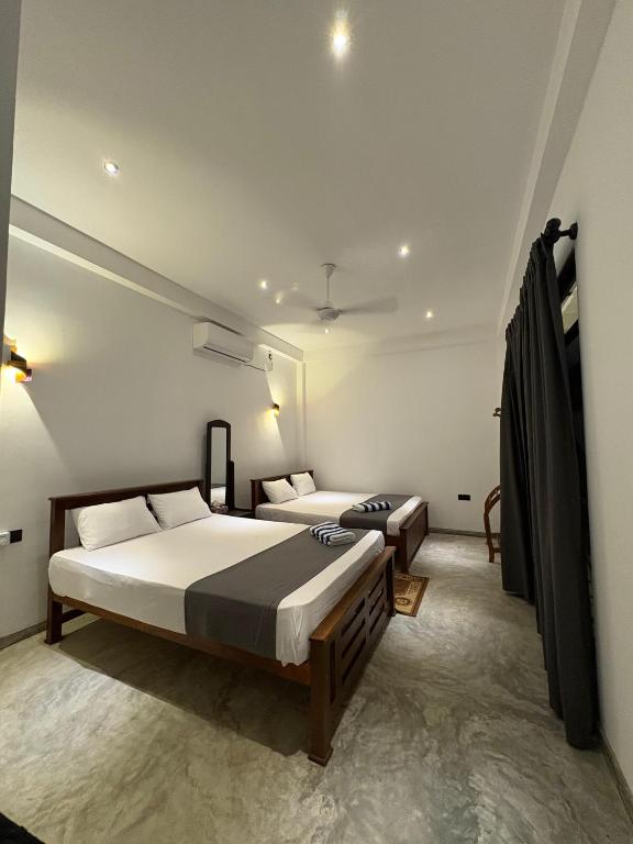 a bedroom with two beds in a room at The Rosemary House in Weligama