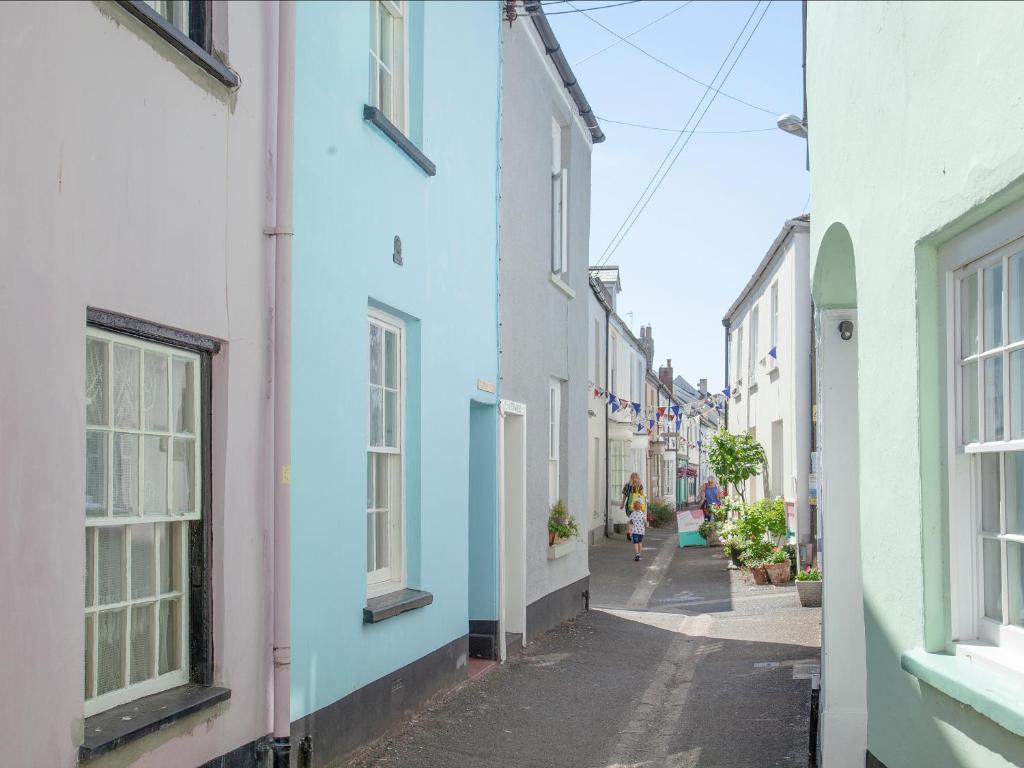 a woman walking down a street in an alley at Tillerman Cottage Appledore Devon in Appledore