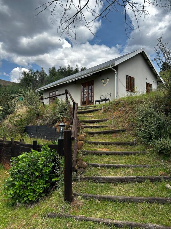 a house on a hill with stairs in front of it at The Keep Cottage in Underberg