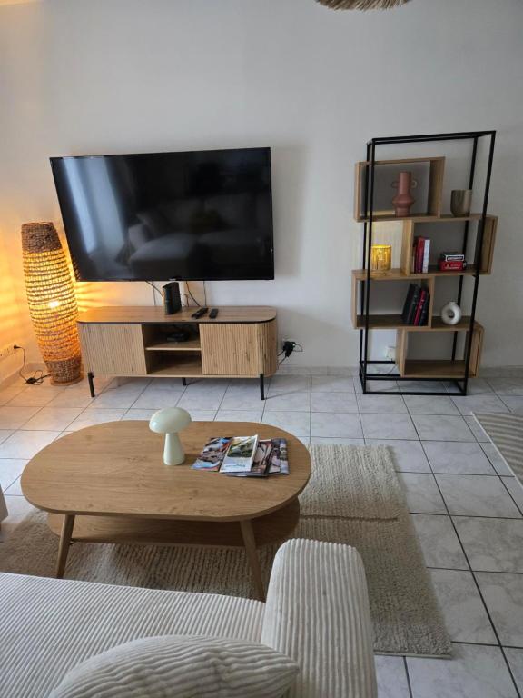 a living room with a large television and a coffee table at Appartement cocooning in Laval