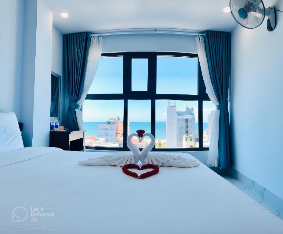 a bedroom with a bed with a large window at Tân Thi Hotel in Quy Nhon