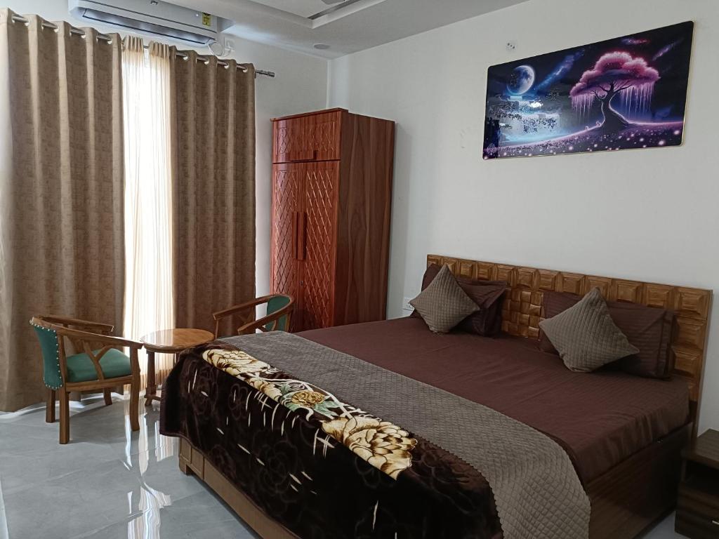 a bedroom with a bed and a table and a window at Aadhya Hotel & Adhira Restaurant in Orchha