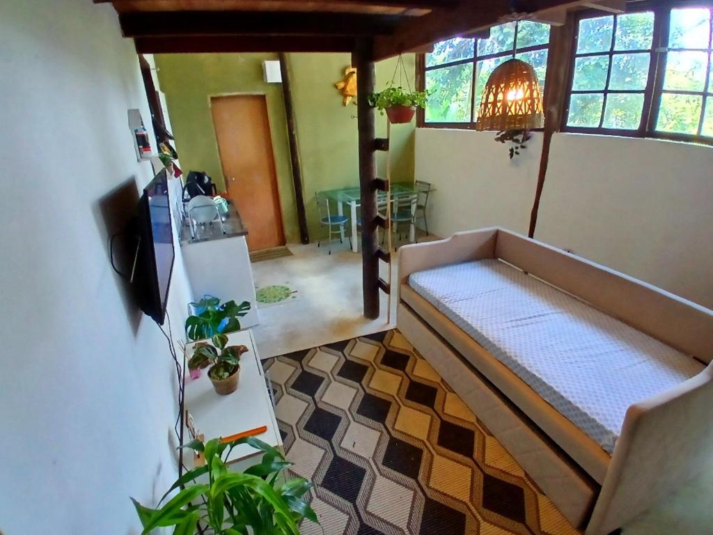 a living room with a couch in a room at Camburi Chalet - por do sol in São Sebastião