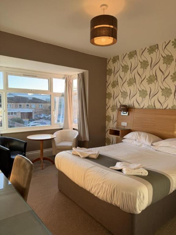 a bedroom with a bed and a table and a window at The Avenue Hotel in Grantham