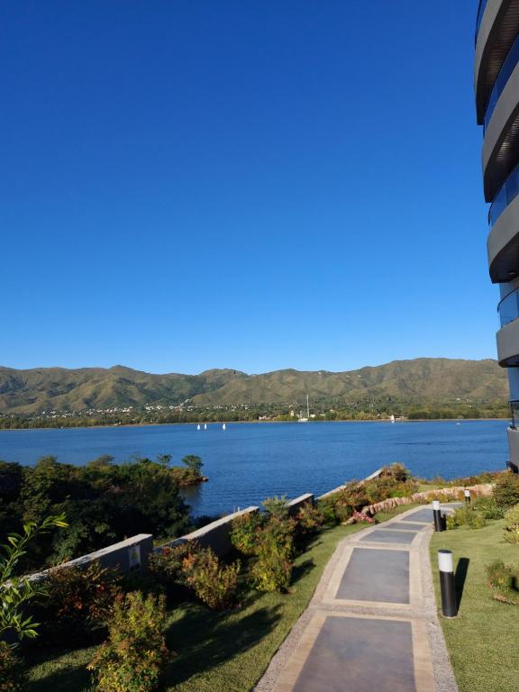 a path next to a body of water at Veneto Village in Villa Parque Siquiman