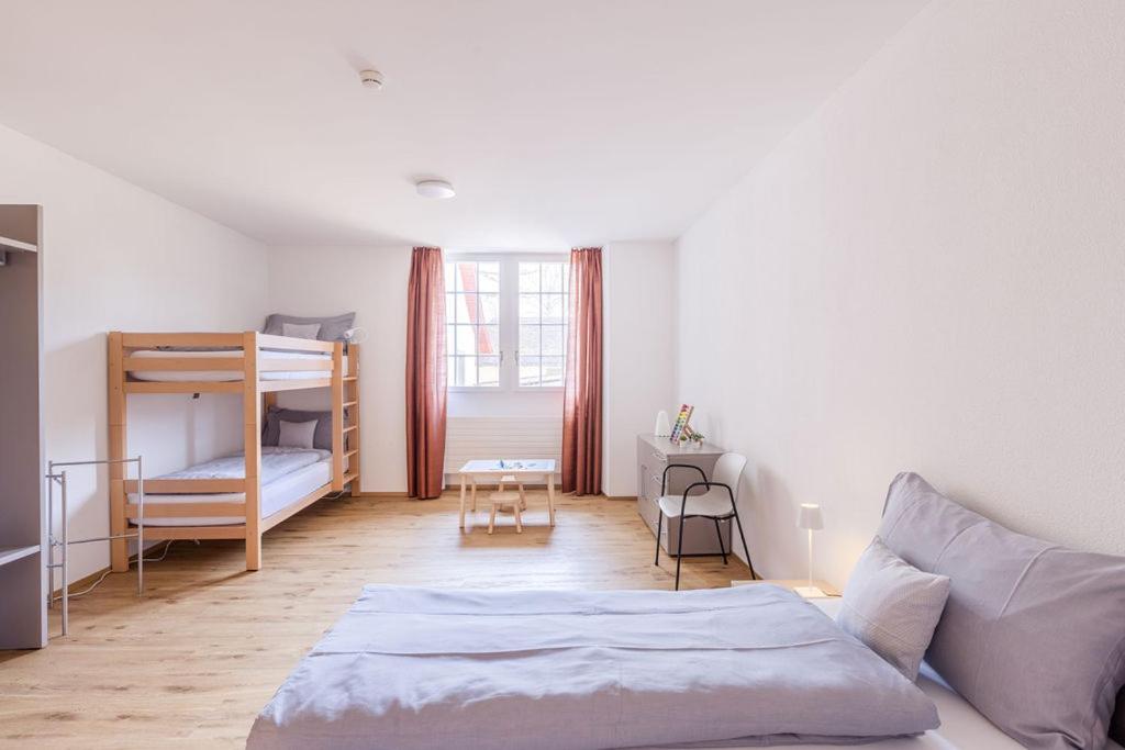 a bedroom with a bed and a bunk bed at Bed and Breakfast Kloster Frienisberg in Seedorf