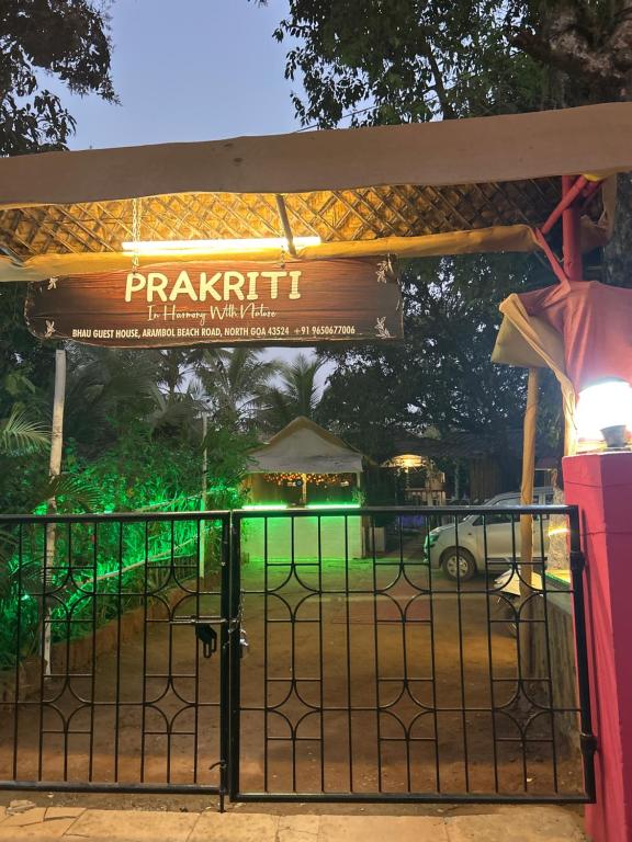 a gate at the entrance to a park at night at Prakriti Resort in Arambol