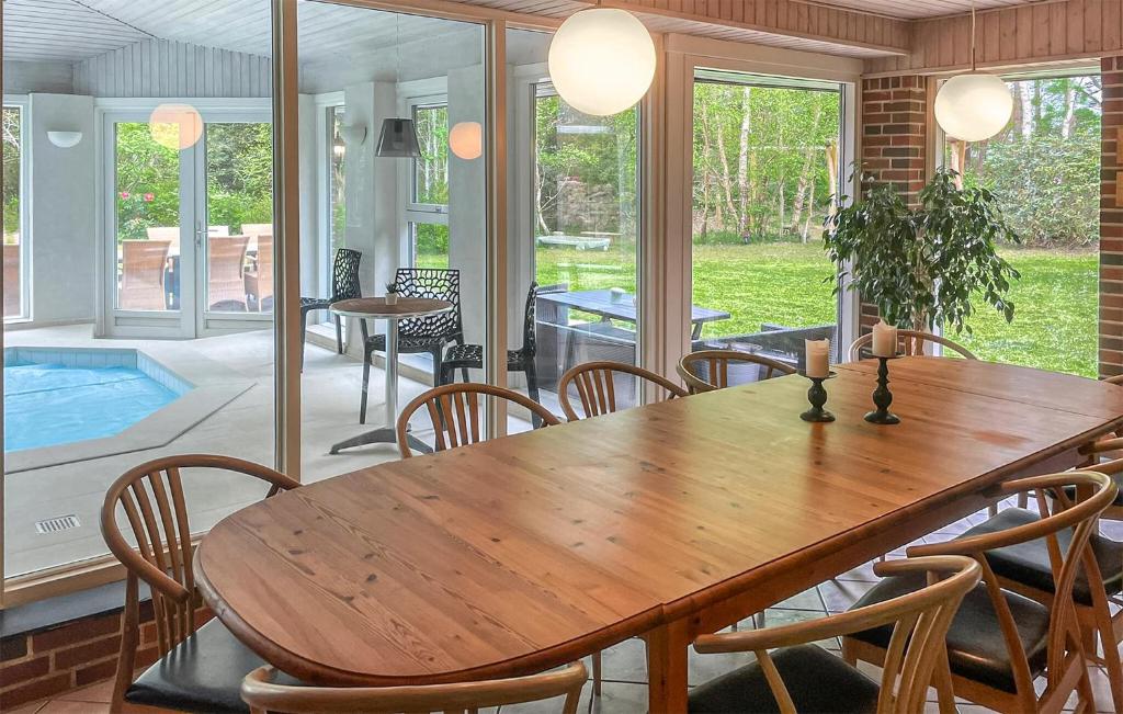 a dining room with a wooden table and chairs at Nice Home In Højby With Sauna in Højby