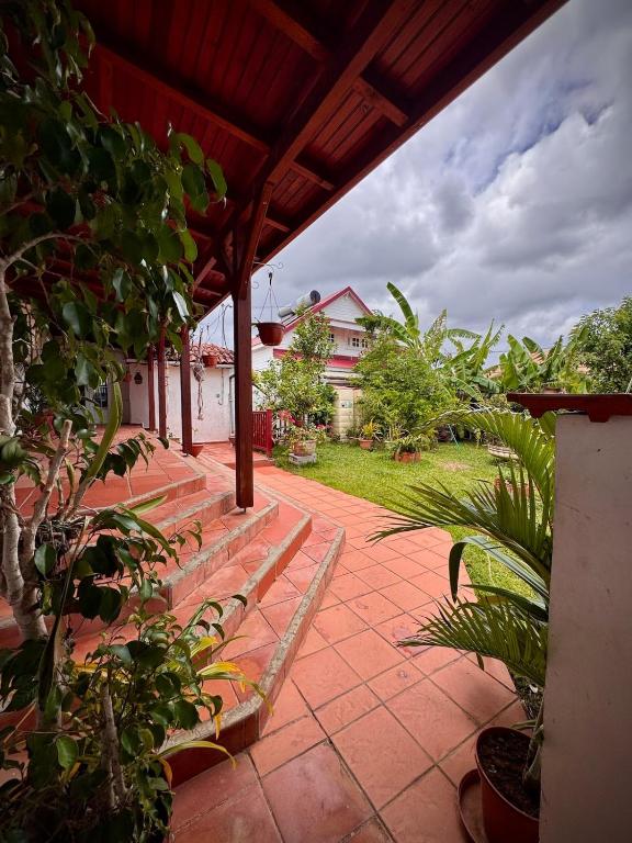 a patio with benches and plants in a yard at Villa Lumineuse in Le Lamentin