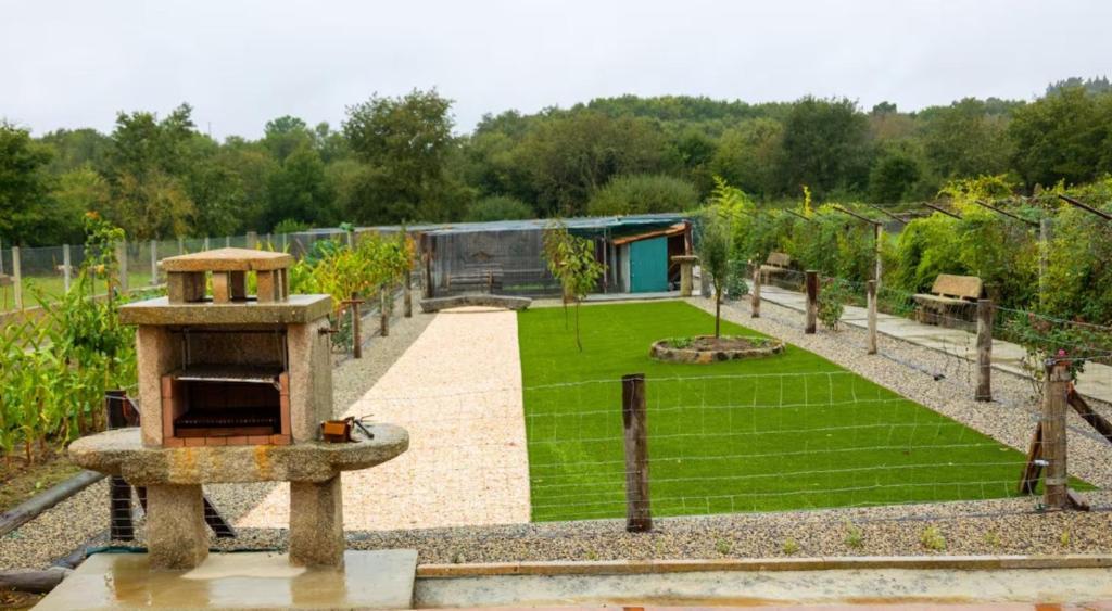 a garden with a bird feeder in the middle at YourHouse Casa Canastro in Allariz