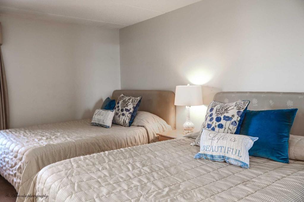 a bedroom with two beds with blue and white pillows at Edgewater 506 Condominium Condo in South Padre Island