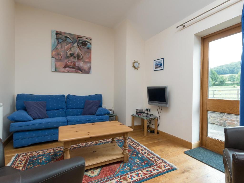 a living room with a blue couch and a table at Parkers Lodge in Mathon