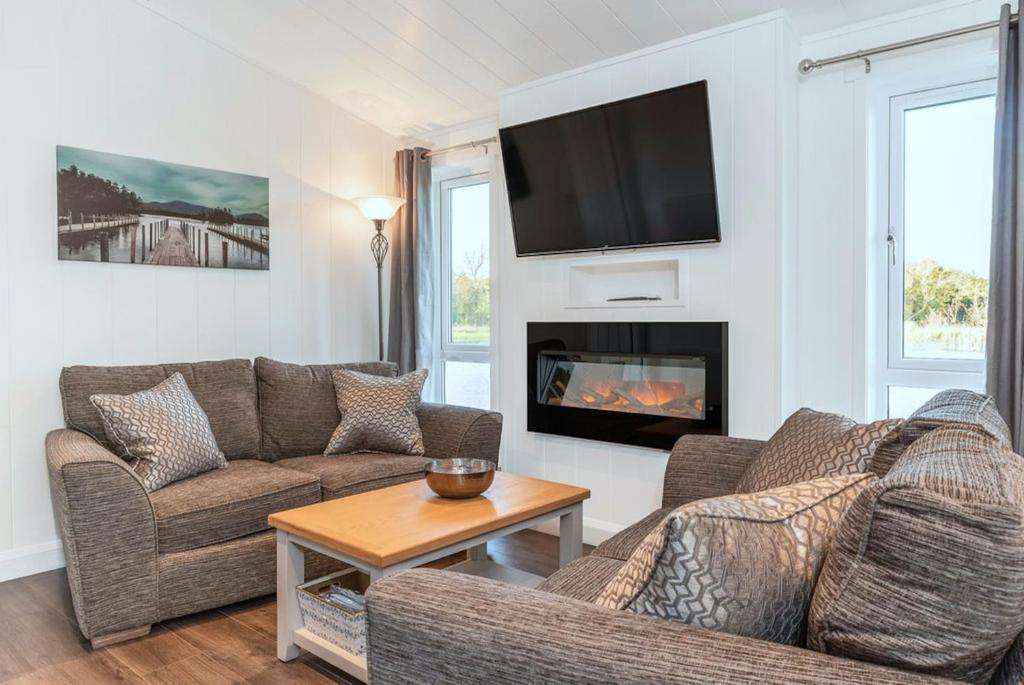 a living room with two couches and a fireplace at Finest Retreats - Silverwood Hideaway Lodge in Errol