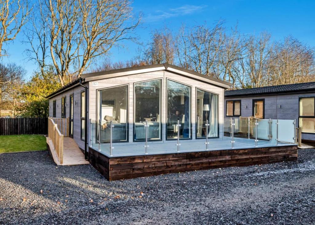 a glass house with a lot of windows at Finest Retreats - Silverwood Deluxe Chalet in Errol