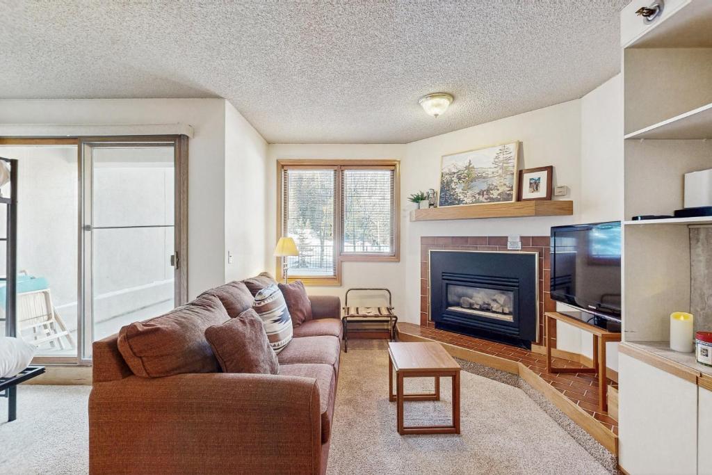 a living room with a couch and a fireplace at Iron Horse Resort #C1083 in Winter Park