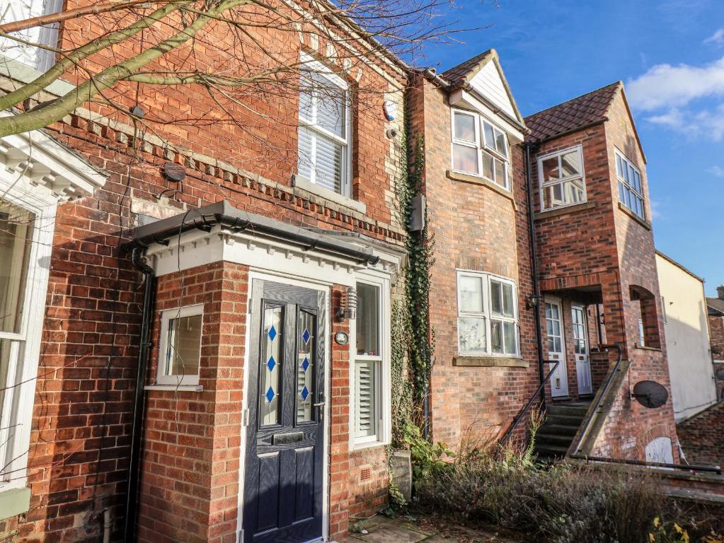 an old brick house with a blue door at 1 Castle Terrace in Thirsk