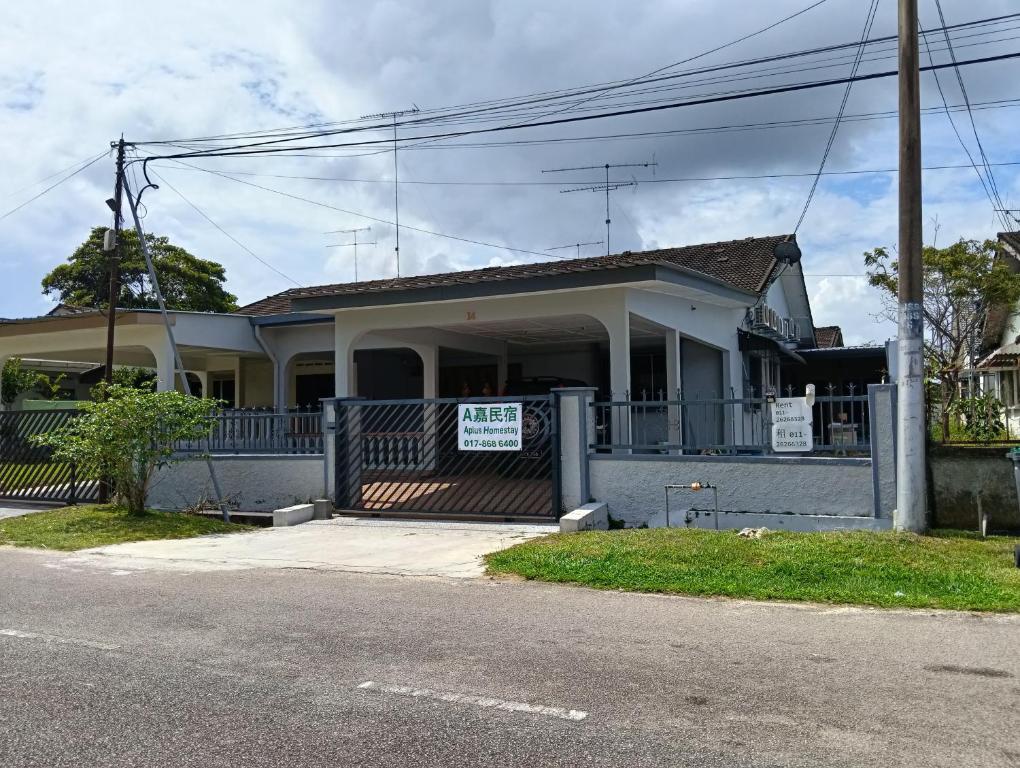a house with a sign on the front of it at Aplus Homestay Kluang A嘉民宿 in Kluang