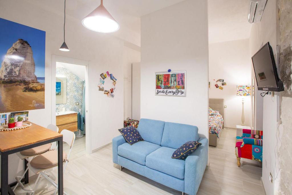 a living room with a blue couch and a table at CasAmica by BarbarHouse in Vieste