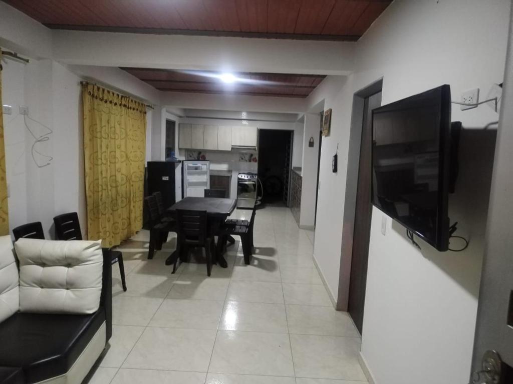 a living room with a table and chairs and a kitchen at Hospedaje Villa Laura in Cite
