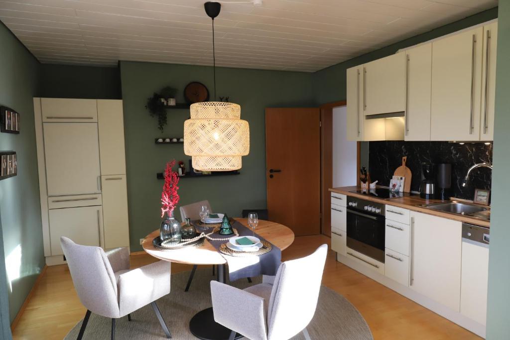 a kitchen with a table and chairs and a kitchen with a sink at Bühler Blick in Bühl