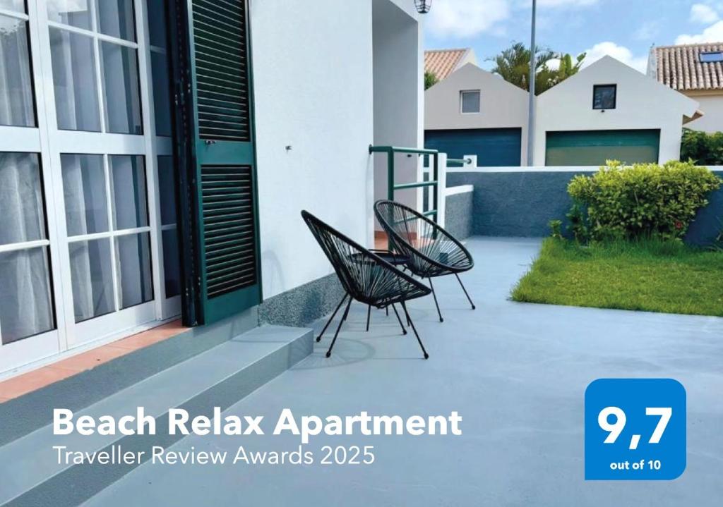 two chairs sitting on a patio in front of a house at Beach Relax Apartment in Porto Santo
