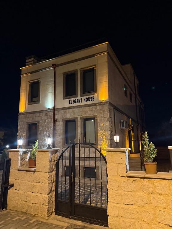 a stone building with a black gate at night at ELEGANT HOUSE Cappadocia in Göreme