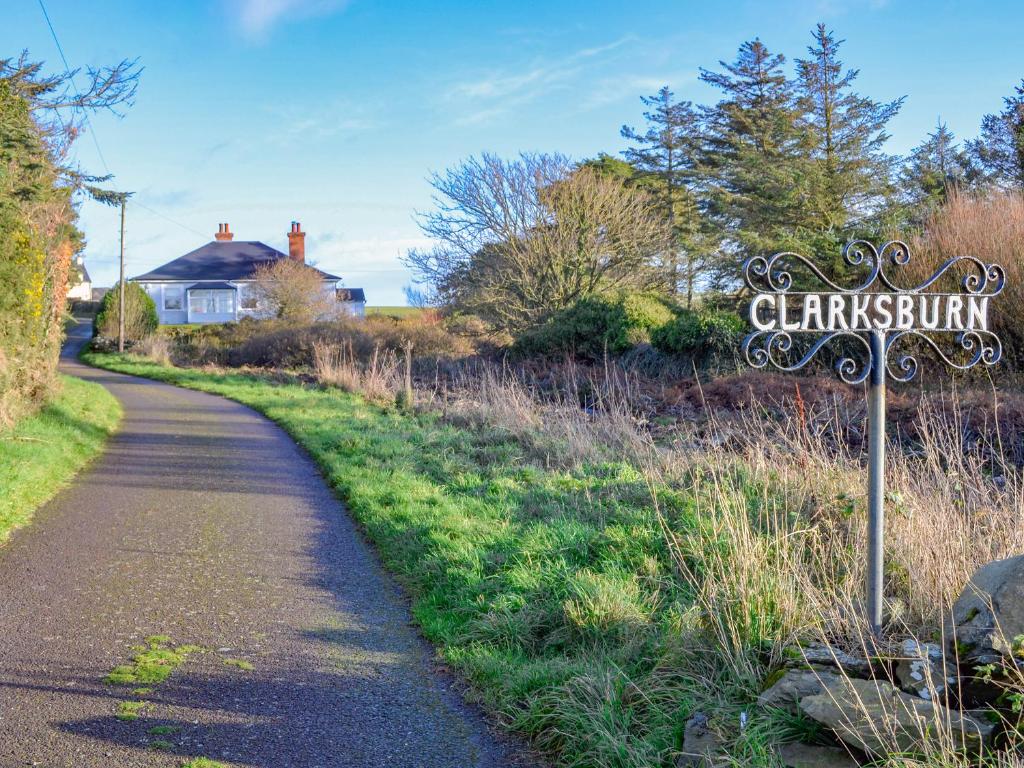 a sign on a path next to a road at Clarksburn Blue in Monreith