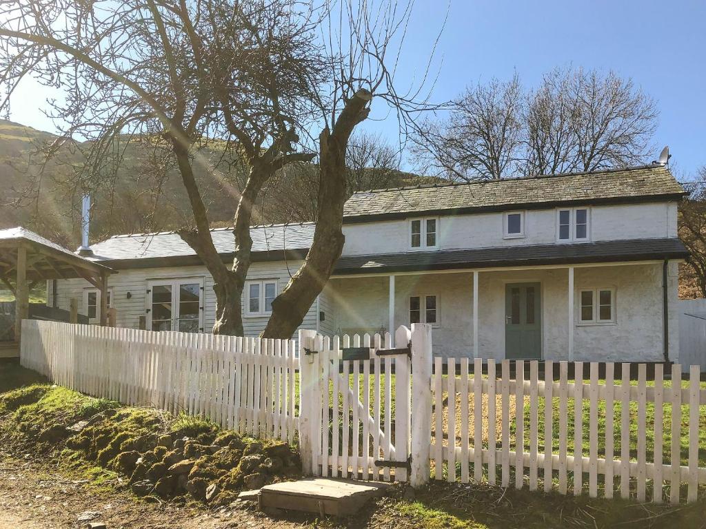 a white picket fence in front of a white house at Middle Hanter - Uk37355 in Old Radnor