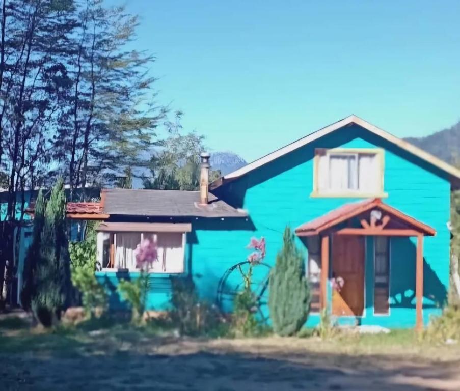 a blue house with a red at Cabañas Jade in Cochamó
