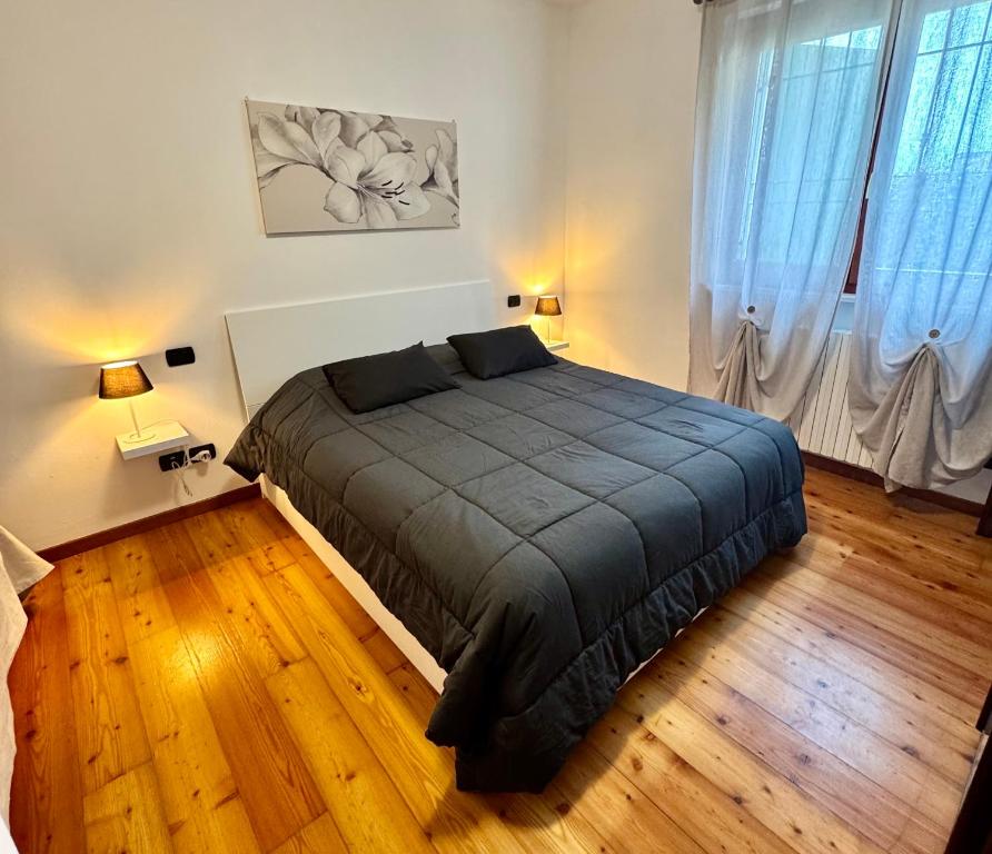a bedroom with a large bed in a room with wooden floors at Top Apartment in Beccacivetta