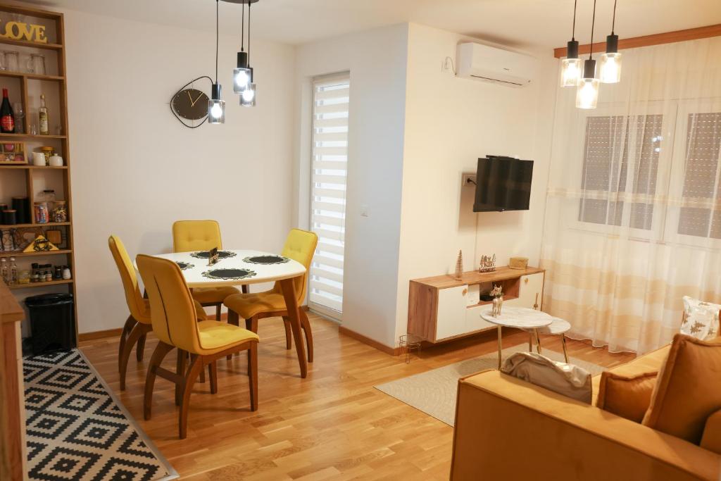 a living room with a table and chairs and a couch at Apartman Wish Lux in Vrnjci